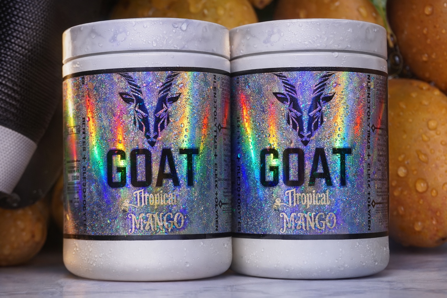 Two containers of 'GOAT Tropical Mango' powder with a colorful label on a marb surface.